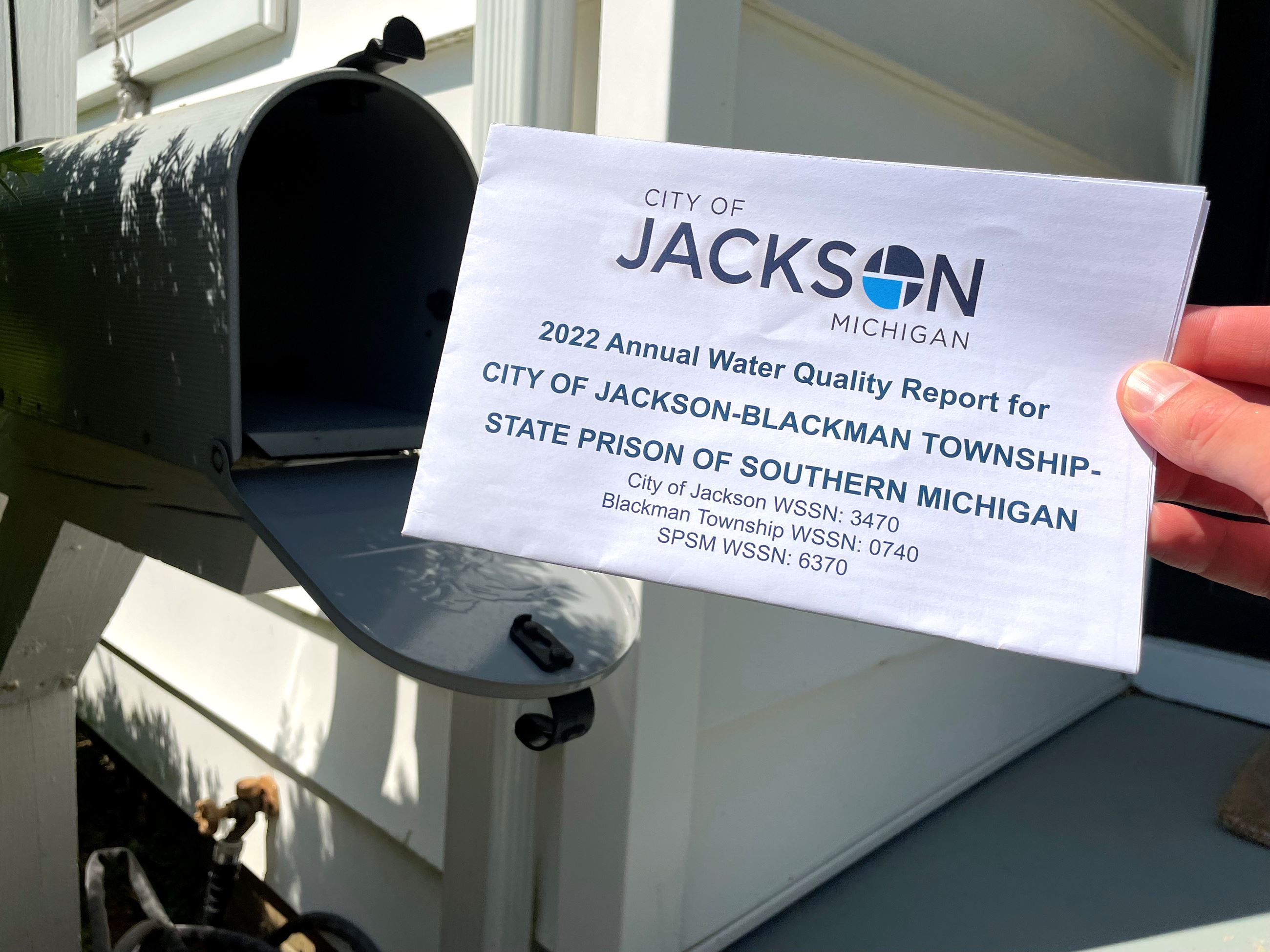 printed report in front of mailbox. text says 2022 water quality report. 