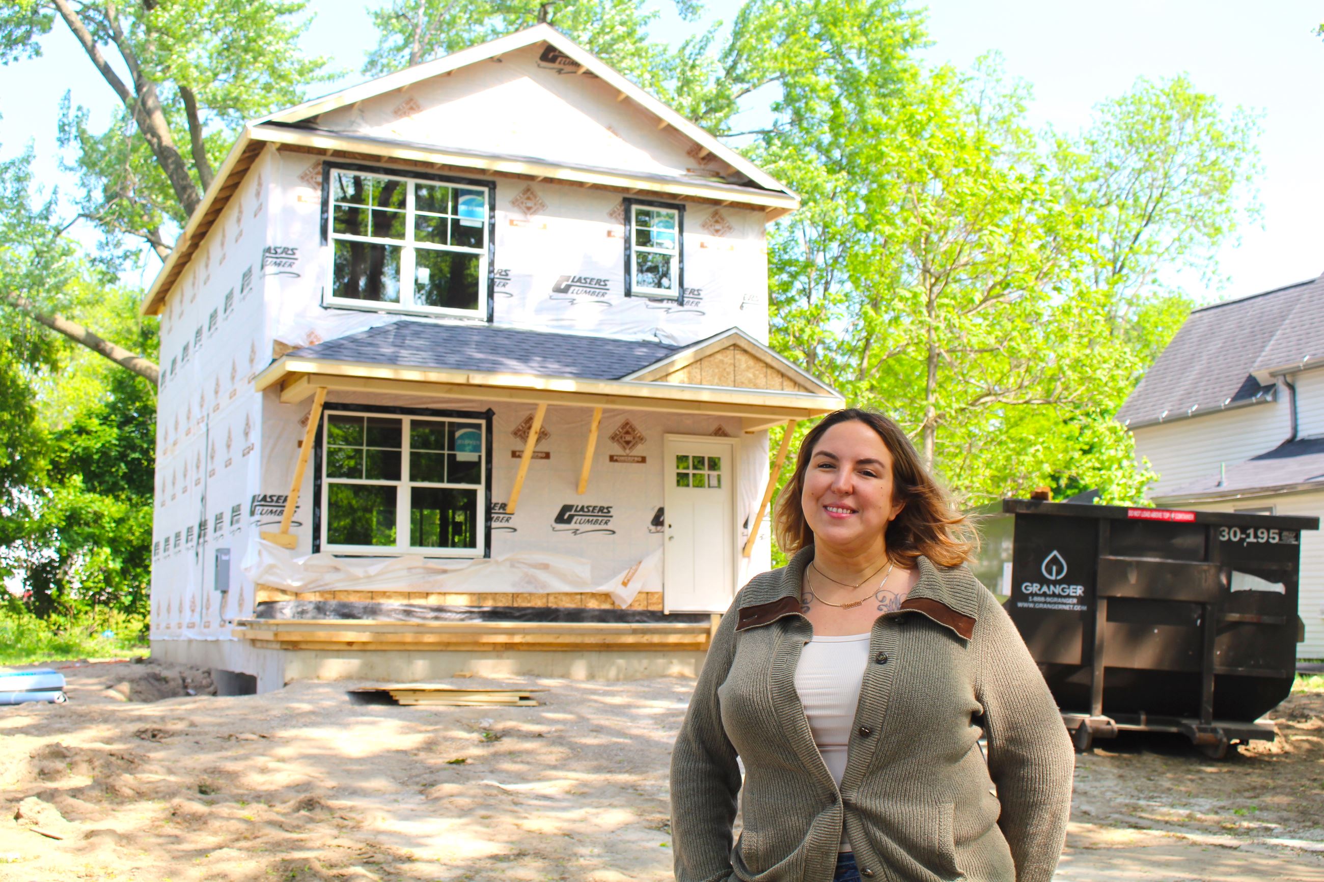 Woman standing with new house on Maltby Street 
