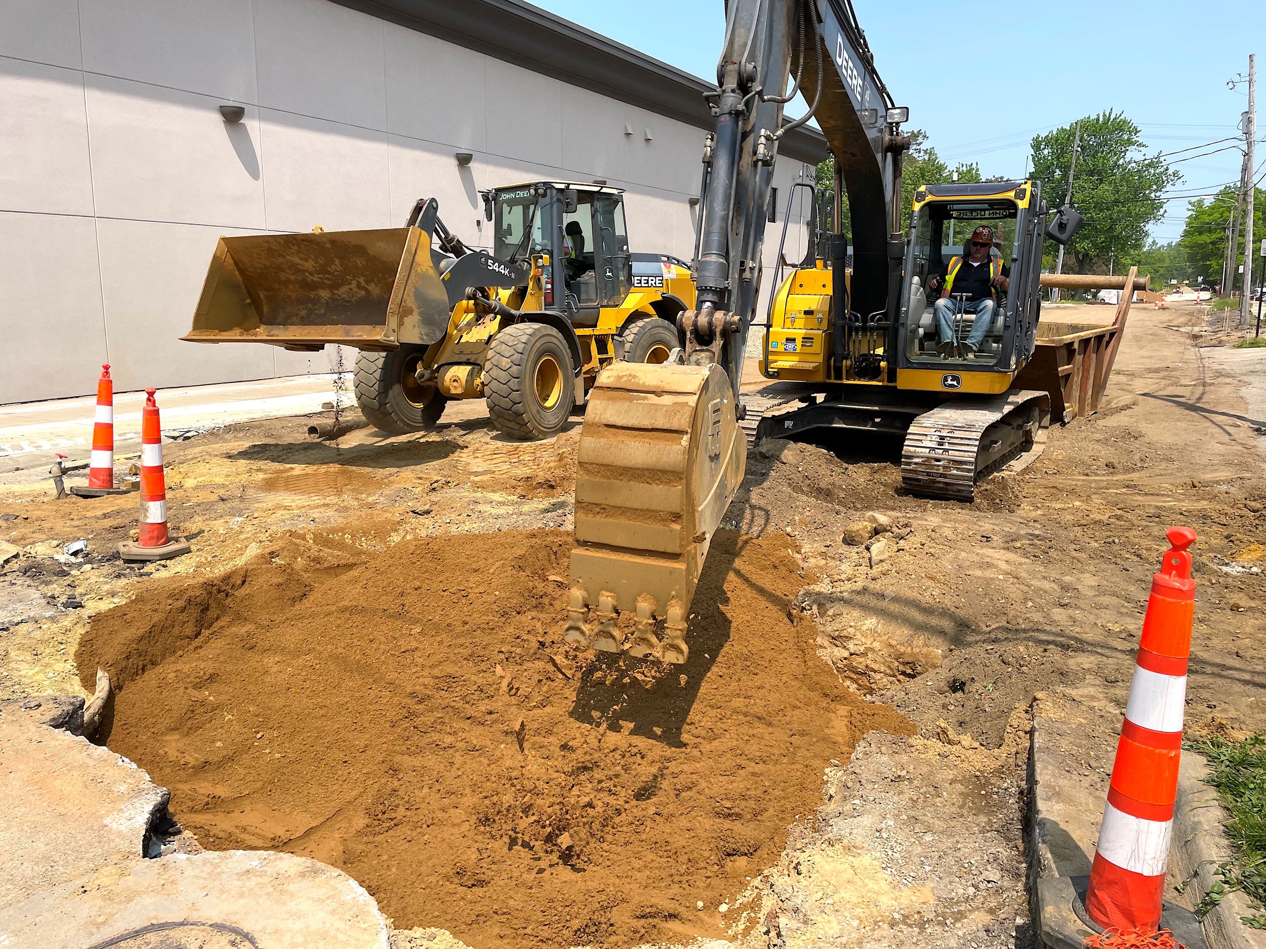 Digging equipment on a street with a big hole