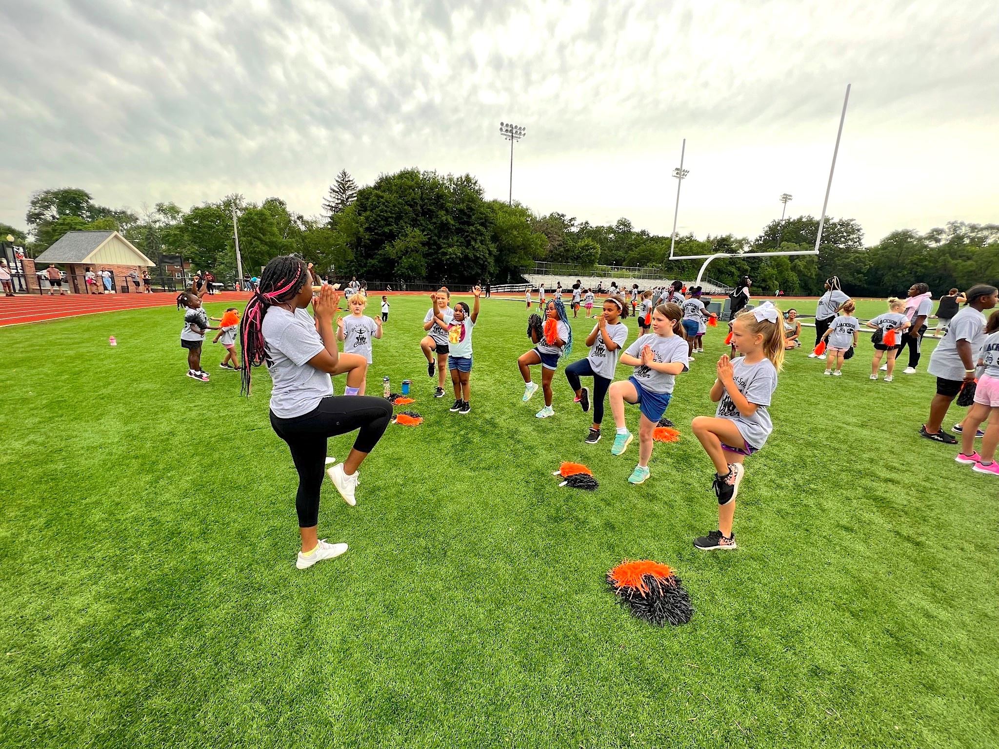 A teenage girl leads younger girls in a cheerleading camp 