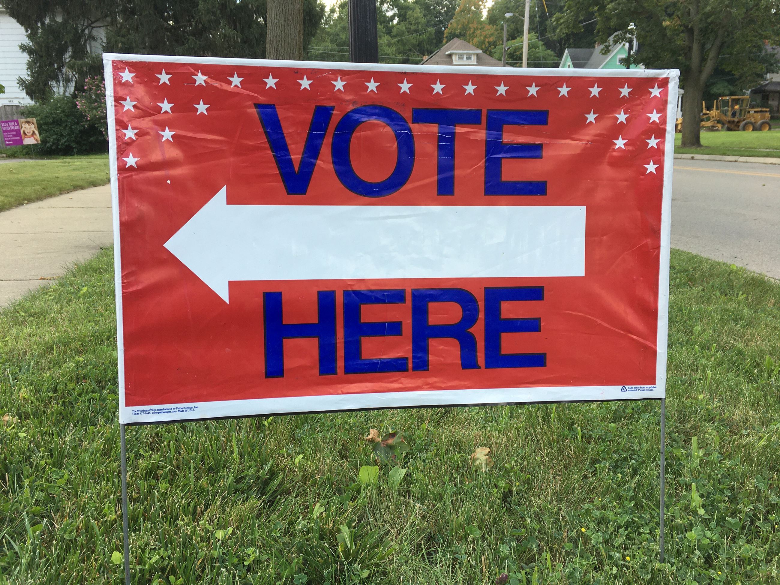 Vote here yard sign displayed outside a polling place. 
